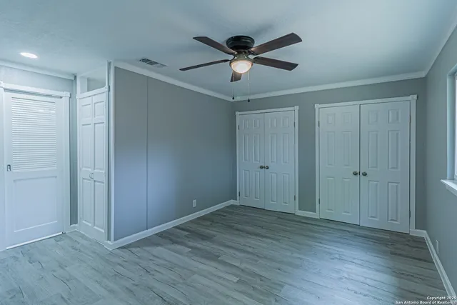 a view of an empty room with wooden floor