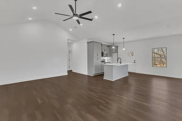 a kitchen with kitchen island a sink wooden floor and a large window