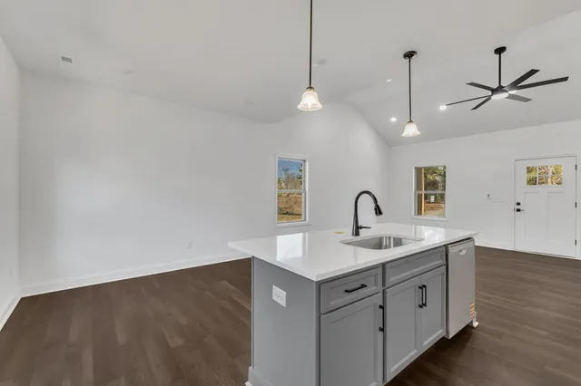 a kitchen with a sink a counter space and a ceiling fan