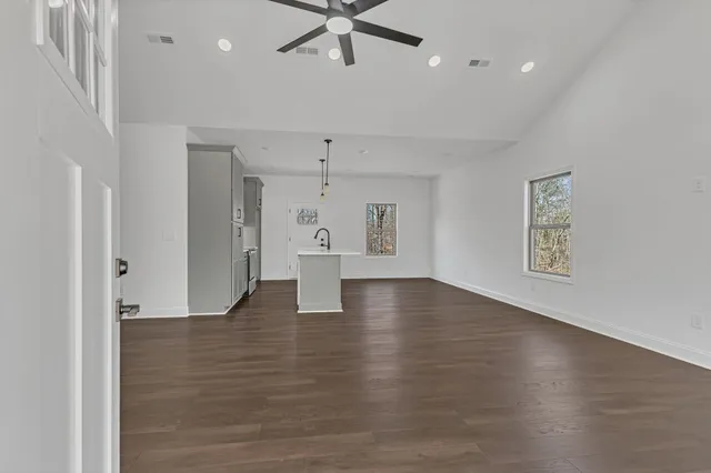 a view of an empty room with wooden floor