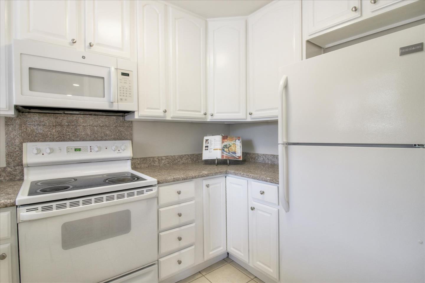 84 Rancho Drive, Unit H San Jose, CA 95111 - Photo 20 of 27 a kitchen with granite countertop white cabinets and white appliances