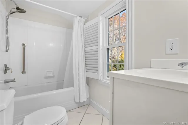 a bathroom with a bathtub shower sink vanity and a toilet