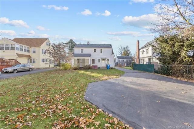 a view of a big house with a big yard and large trees