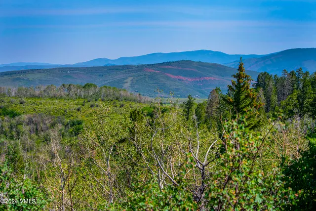 a view of mountain with sunset in background