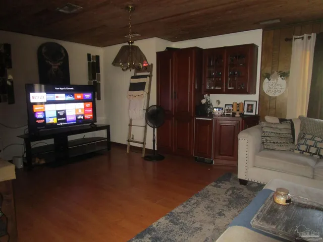 a living room with furniture a flat screen tv and kitchen view