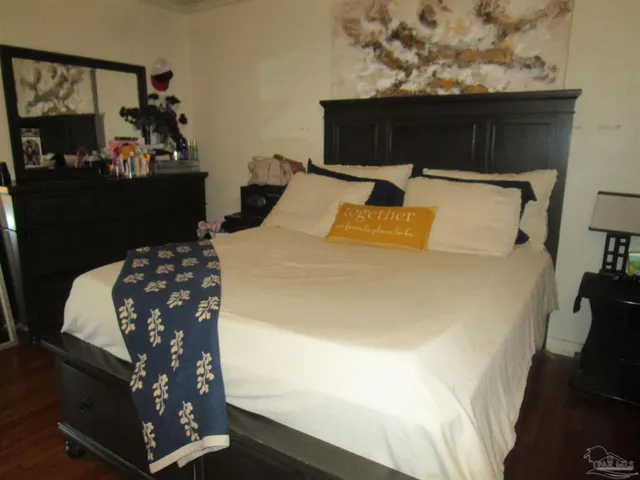 a bed sitting in a bedroom next to a window with potted plants