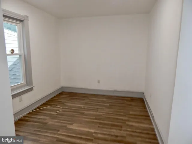 a view of a room with wooden floor and a window