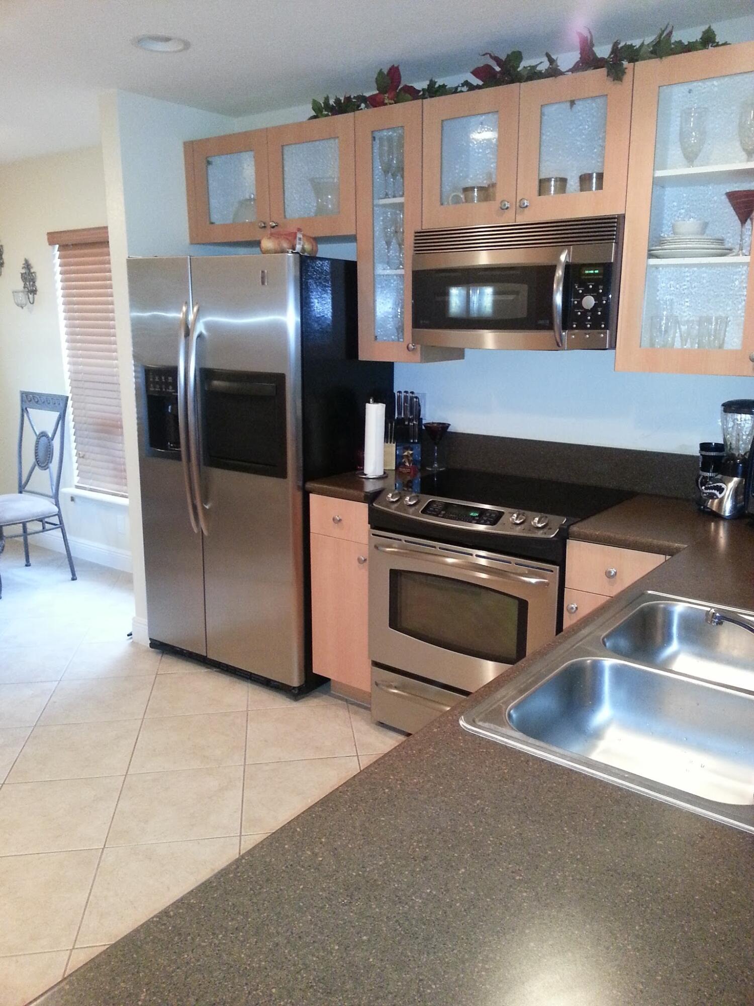 10012 Southwest 23rd Street Miramar, FL 33025 - Photo 2 of 6 a kitchen with stainless steel appliances granite countertop a stove a microwave and a refrigerator