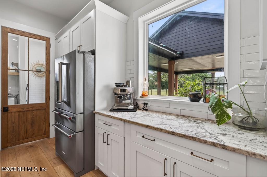 2955 Carroll Corner Road Hilliard, FL 32046 - Photo 42 of 106 a kitchen with stainless steel appliances granite countertop a refrigerator a sink and a large window