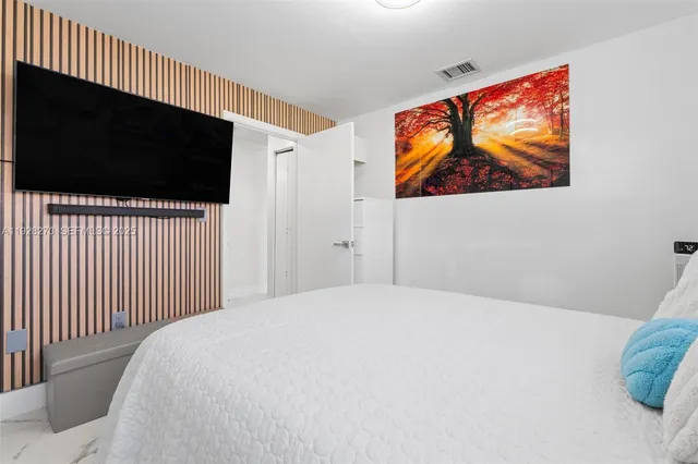 a bedroom with a bed and a flat screen tv