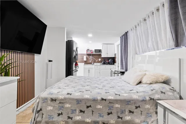 a large bedroom with a bed and a flat screen tv