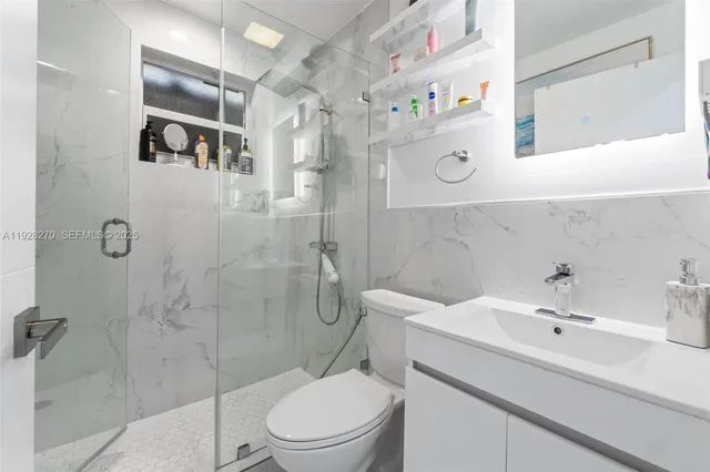 a bathroom with a sink a toilet and shower