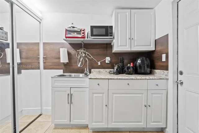 a kitchen with stainless steel appliances granite countertop a refrigerator and cabinets
