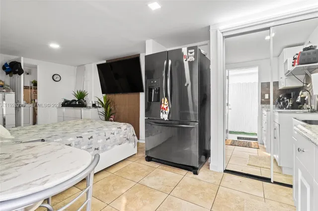 a kitchen with stainless steel appliances kitchen island granite countertop a refrigerator and a sink
