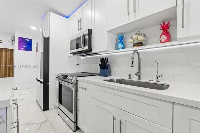 a kitchen with stainless steel appliances granite countertop a sink and a stove