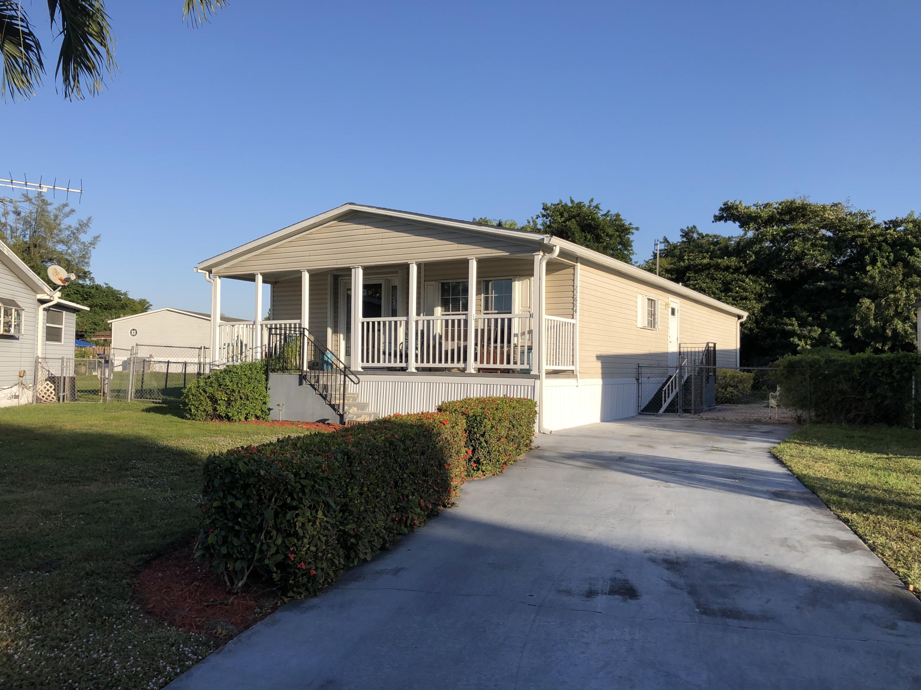 22884 Neptune Road Boca Raton, FL 33428 - Photo 1 of 19 a front view of a house with a yard