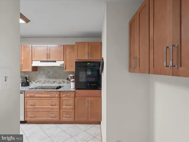 a kitchen with granite countertop a refrigerator and cabinets