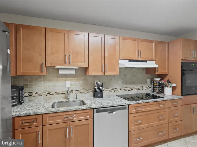a kitchen with granite countertop white cabinets sink and window