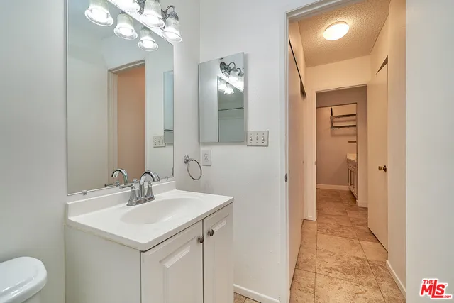 a bathroom with a sink a toilet and mirror