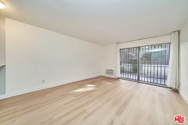 a view of a room with wooden floor and a window