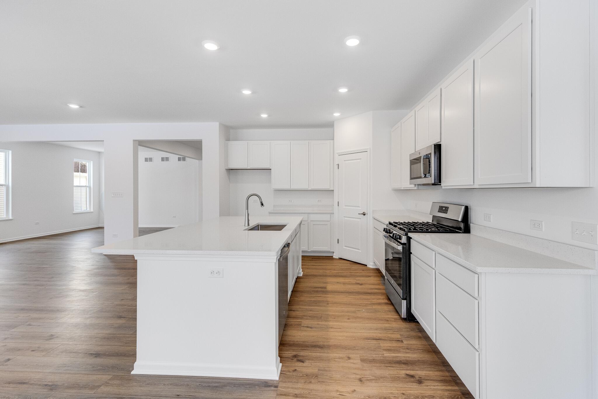 5948 East 112th Avenue Winfield, IN 46307 - Photo 14 of 36 a large kitchen with stainless steel appliances lots of counter space and wooden floor