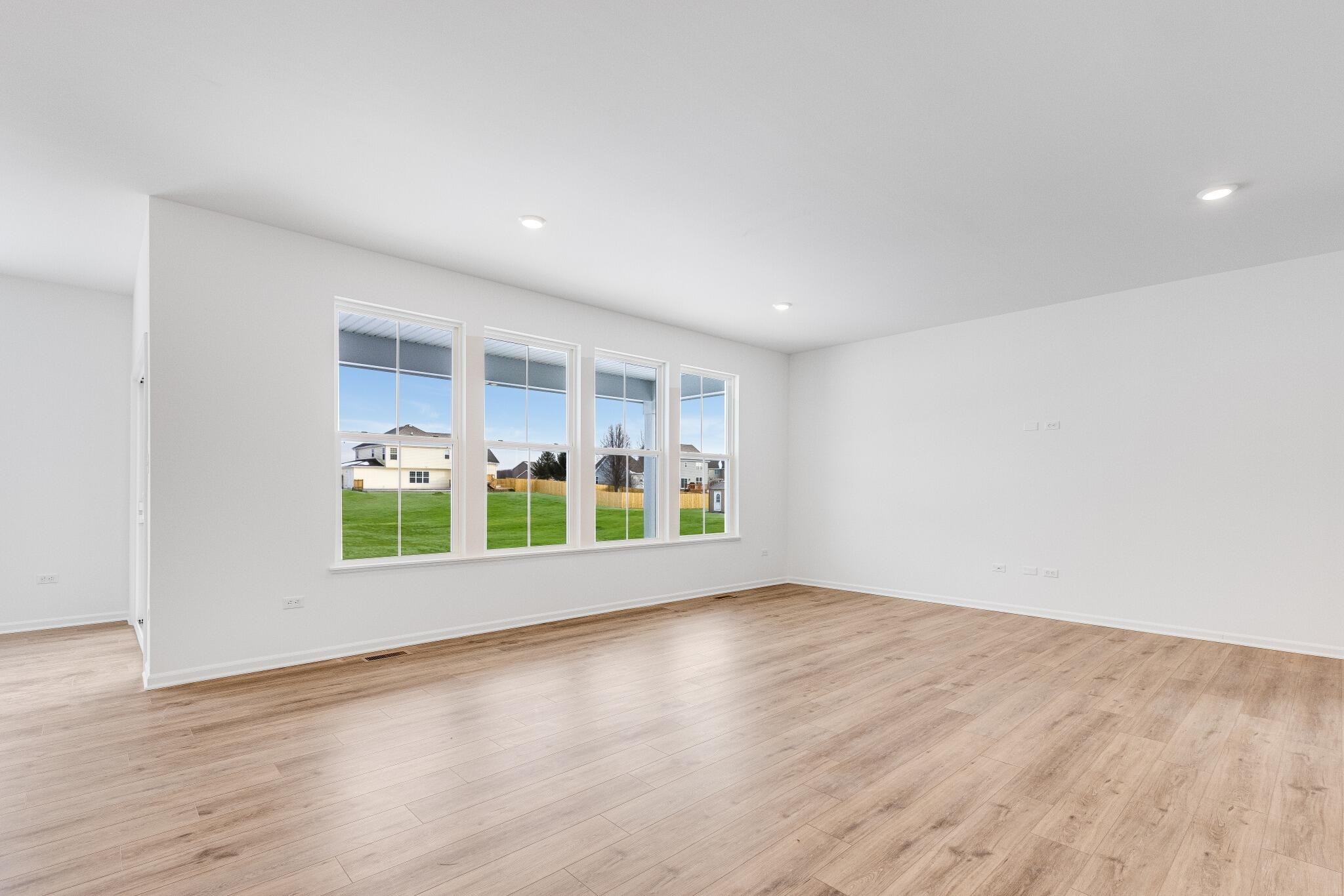 5948 East 112th Avenue Winfield, IN 46307 - Photo 21 of 36 a view of an empty room with a window and wooden floor