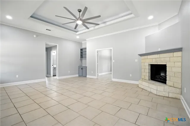 an empty room with fireplace and windows