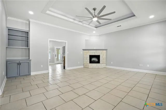 an empty room with windows and ceiling fan