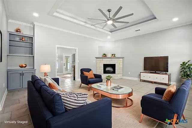 a living room with furniture a flat screen tv and kitchen view