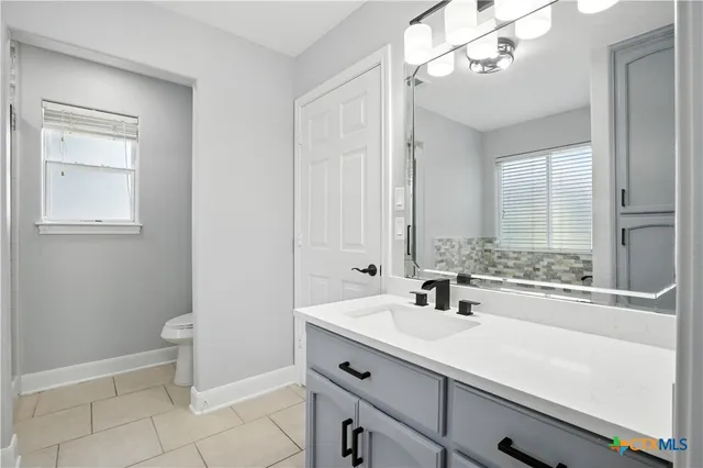 a bathroom with a tub sink and mirror