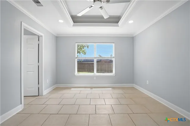 an empty room with windows and fan