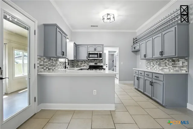a kitchen with a sink stove and cabinets