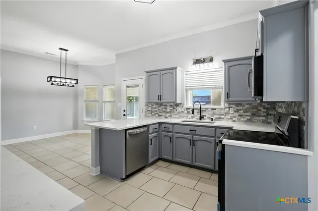 a kitchen with granite countertop a sink stove and refrigerator