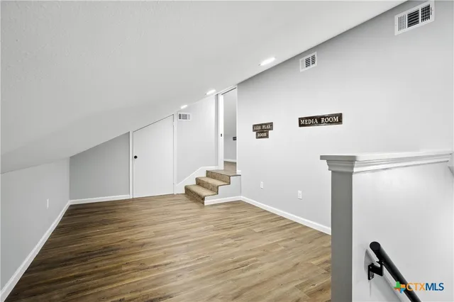 a view of an empty room with wooden floor