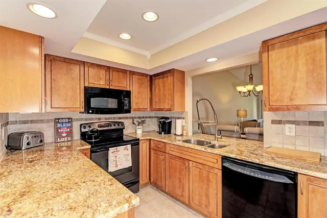 a kitchen with stainless steel appliances granite countertop a sink and a stove