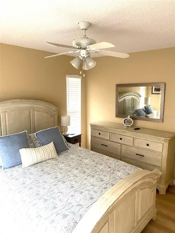 a bedroom with a large bed and a flat tv screen on dresser