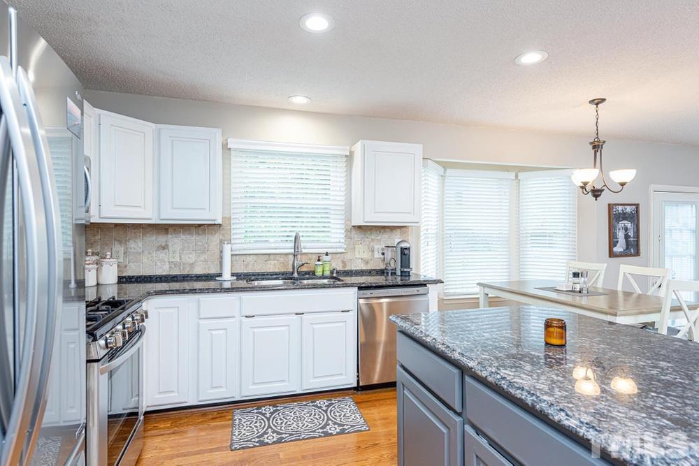 2316 Declaration Drive Raleigh, NC 27615 - Photo 8 of 30 a kitchen with granite countertop a sink a stove and cabinets