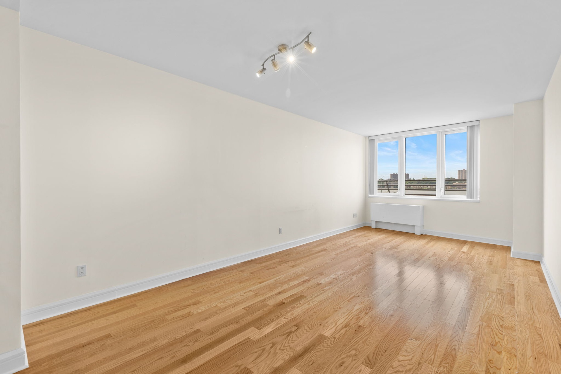 120 Riverside Boulevard, Unit 5H Manhattan, NY 10069 - Photo 3 of 17 a view of an empty room with wooden floor and a window