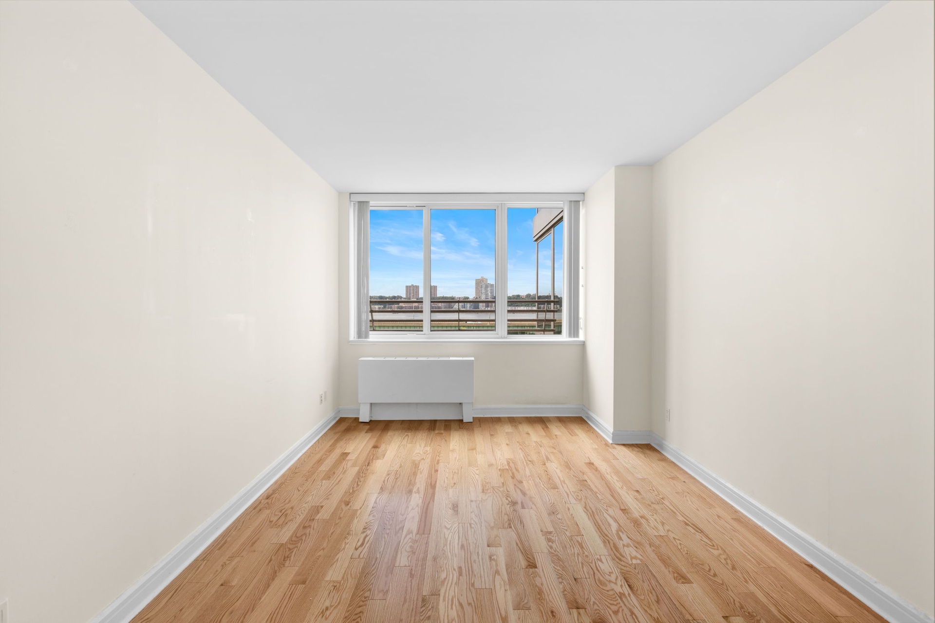 120 Riverside Boulevard, Unit 5H Manhattan, NY 10069 - Photo 6 of 17 a view of a room with wooden floor electronic appliances and window