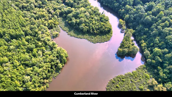a sign board with a house in the background