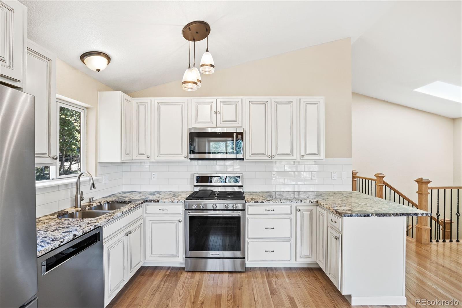 122 South Random Road Bailey, CO 80421 - Photo 11 of 38 a kitchen with granite countertop a sink stainless steel appliances and cabinets