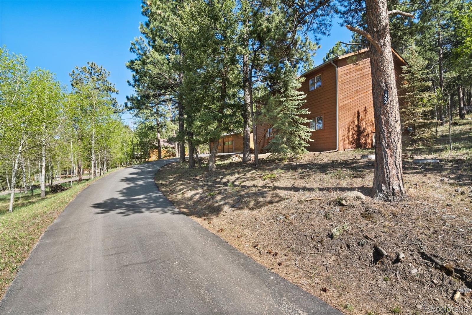 122 South Random Road Bailey, CO 80421 - Photo 30 of 38 a view of a house with a yard