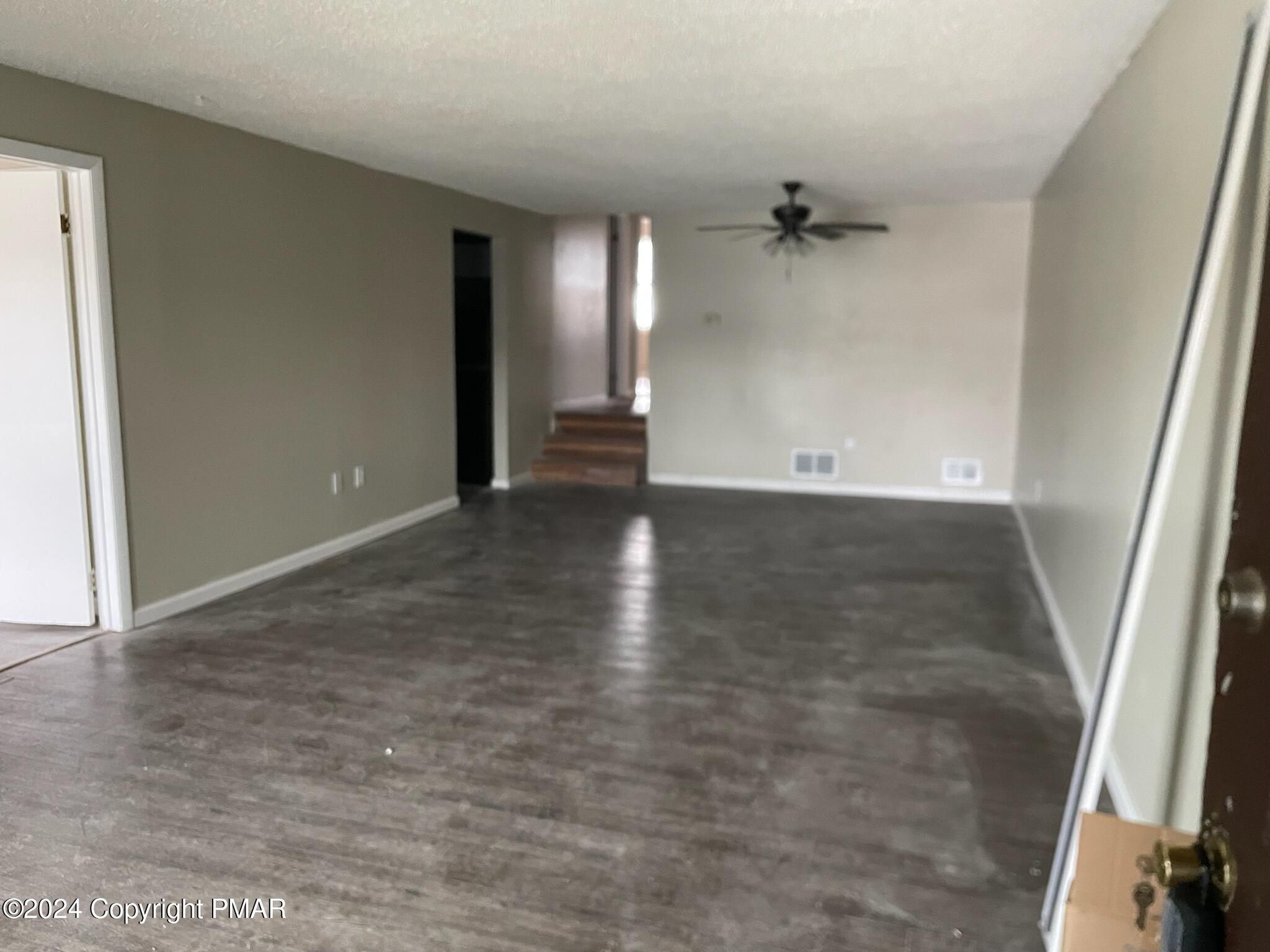 107 Snowshoe Court Mount Pocono, PA 18344 - Photo 2 of 3 an empty room with staircase and white walls