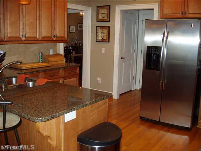 1700 Rita Court Oak Ridge, NC 27310 - Photo 4 of 16 Kitchen. This kitchen offers hardwood floors, granite counter tops, a tile backsplash, ceramic cook top, microwave and the existing refrigerator.