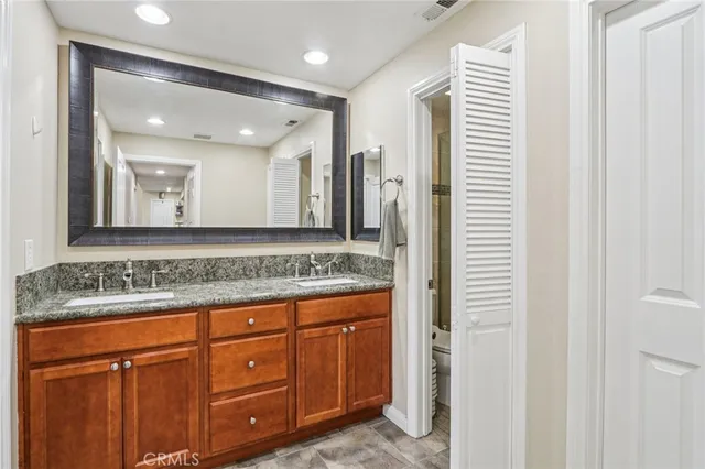 a bathroom with a granite countertop sink and a mirror