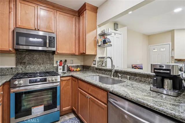 a kitchen with granite countertop a stove sink and microwave