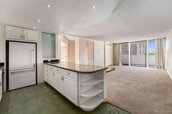 a kitchen with stainless steel appliances granite countertop a refrigerator and a stove