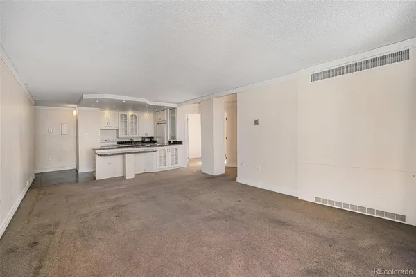 a view of kitchen with refrigerator and white cabinets