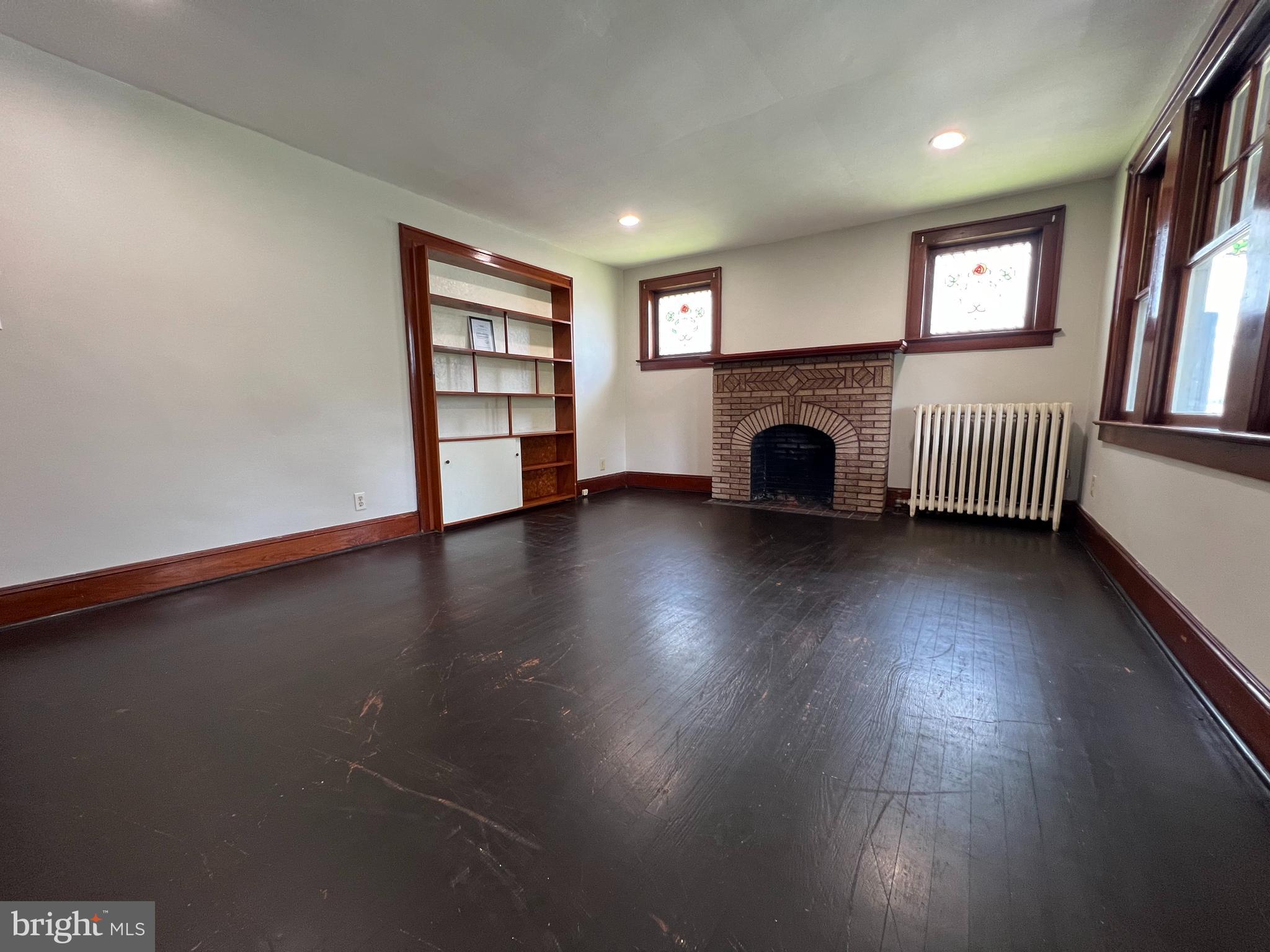 8 Ewington Avenue, Unit 1 Ewing, NJ 08638 - Photo 2 of 5 an empty room with windows and fireplace