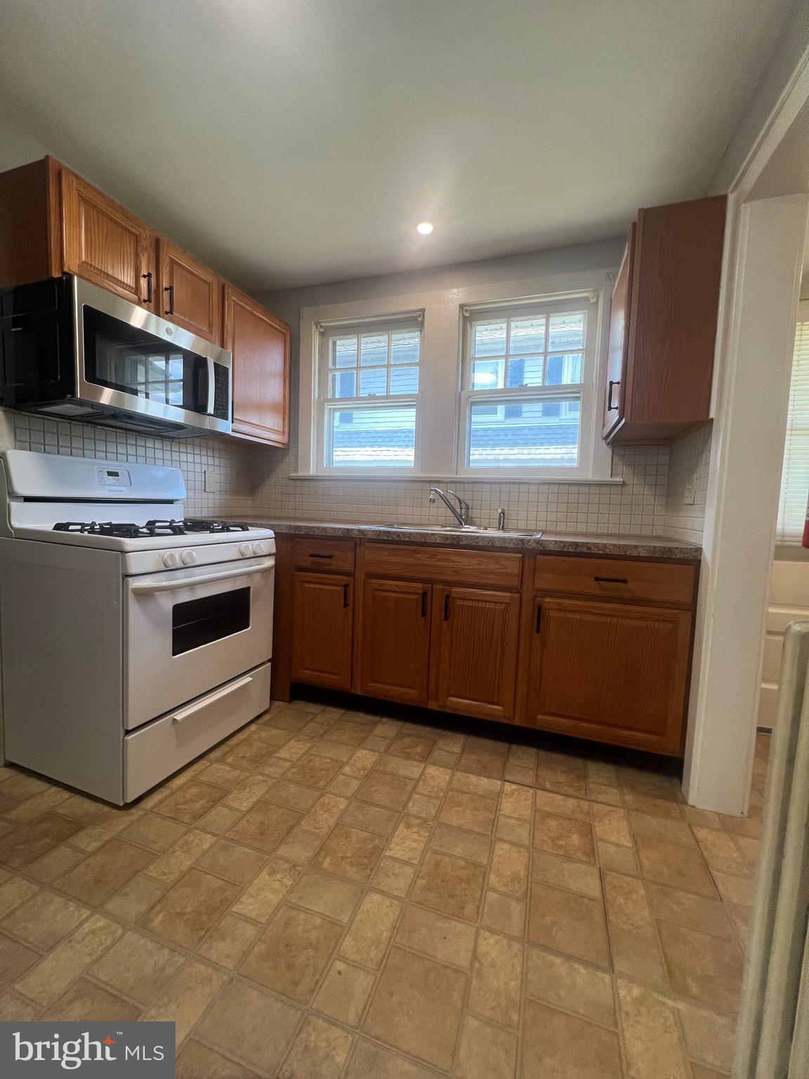 8 Ewington Avenue, Unit 1 Ewing, NJ 08638 - Photo 3 of 5 a kitchen with stainless steel appliances granite countertop a stove a sink and a microwave